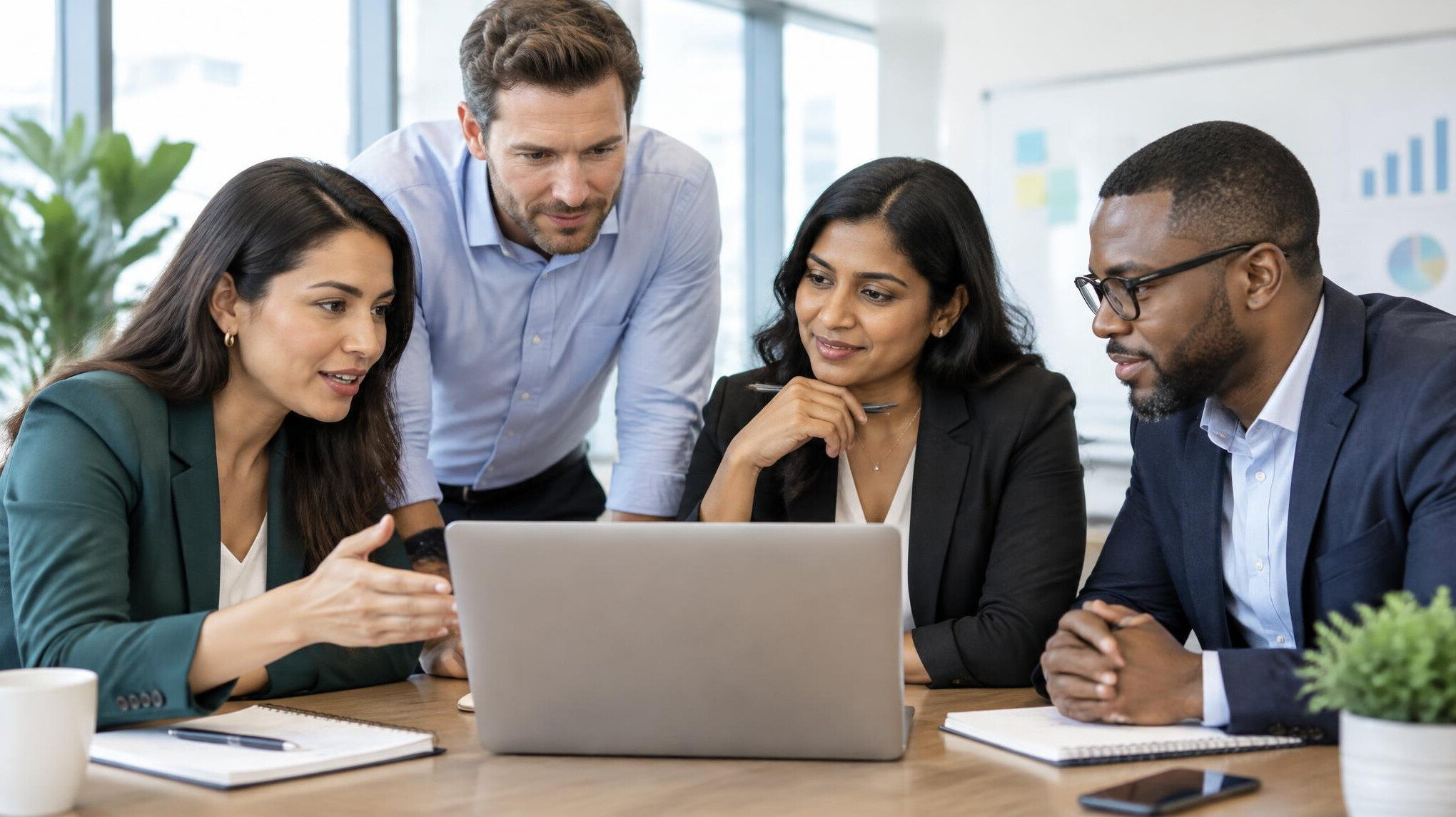 Group of professionals in discussion around a laptop during a planning session